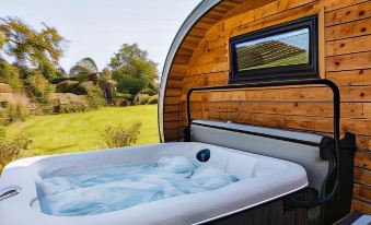 a hot tub is situated in a wooden structure with a view of the countryside at Damson Dene Hotel