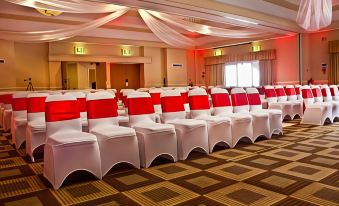 a large banquet hall with rows of chairs arranged in a symmetrical fashion , possibly for an event at Airport Inn Manchester