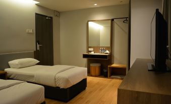 a hotel room with two beds , a desk , and a mirror , giving it a clean and modern feel at Go Hotel