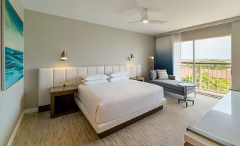 a modern hotel room with white bedding , a large window offering city views , and comfortable seating arrangements at Hyatt Regency Aruba Resort, Spa and Casino