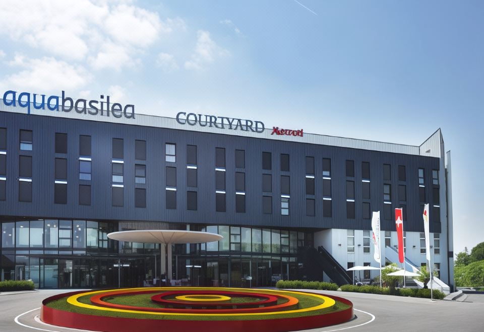 the exterior of the basilico courtyard hotel with a red and yellow flower in the foreground at Courtyard Basel