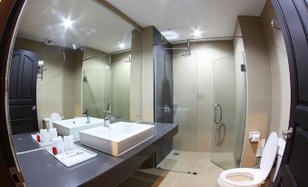 a modern bathroom with a large mirror , white sink , and glass shower enclosure , as well as a toilet and sink at White Inn Nongkhai Hotel