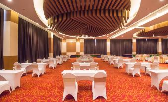 a large conference room with white tables and chairs arranged in rows , under a wooden ceiling at Atria Hotel Malang