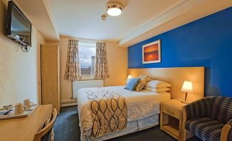 a hotel room with a large bed , a desk , and a window , all decorated in a modern style at Royal Maritime Hotel