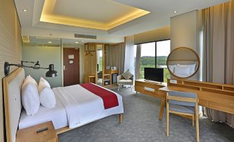 a hotel room with a king - sized bed , a desk , a chair , and a flat - screen tv at FamVida Hotel Lubuklinggau Powered by Archipelago