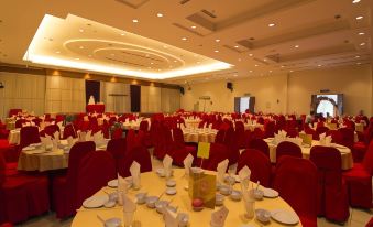 a large banquet hall filled with tables and chairs , ready for a formal event or a wedding reception at Garden View Hotel