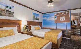 a hotel room with two beds , each bed having a yellow blanket and a white comforter , under a ceiling decorated with a mural of the at Hotel El Rancho