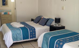 a room with two beds , one on the left and one on the right side of the room at Black Marlin Motel