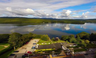 aerial view of a large body of water surrounded by green hills and a road with parked cars at Beech Hill Hotel & Spa