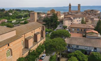 a view of a town with a red brick building and cars parked in front at Hotel Vannucci