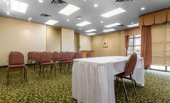 a conference room with a long table and chairs , surrounded by curtains and large windows at Quality Inn & Suites Bay Front