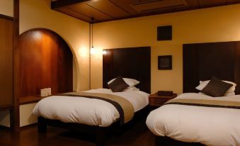 a hotel room with two beds , one on the left and one on the right side of the room at Miyako
