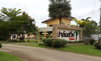 "a large yellow building with a sign that reads "" bananau "" is surrounded by palm trees and bushes" at Palm Sweet Resort