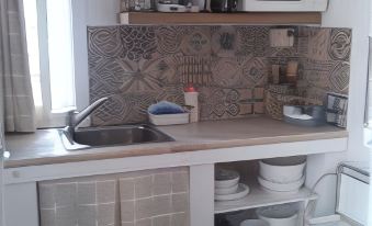 a small kitchen with a sink , stove , microwave , and refrigerator , as well as a microwave above the sink at La Posada