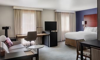 a hotel room with a bed , desk , and tv , as well as a living area with a couch and tv at Residence Inn Philadelphia Willow Grove