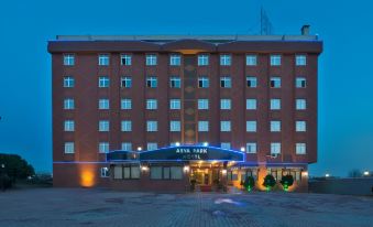 "a brick building with a blue awning and the name "" assa park "" on it , set against a dark blue sky" at Emirtimes Hotel&Spa - Tuzla
