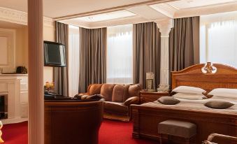 a luxurious hotel room with red carpeted floors , wooden furniture , and a large window offering views of the city at Hotel Europe