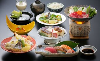 a table is filled with various plates of food , including sushi and other dishes , in a restaurant setting at Jukeiso