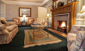 a cozy living room with a fireplace , two couches , and several chairs arranged around it at Ees Wyke Country House