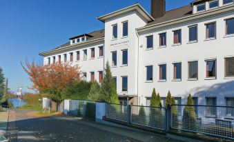 "a white building with the name "" silmerhaus "" on it , surrounded by trees and other buildings" at Hotel am Rhein