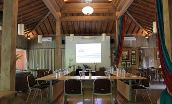 a conference room with a large screen and chairs set up for a meeting or presentation at Rumah Batu Boutique Hotel