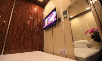 a spacious bedroom with a king-sized bed and a wall-mounted flat-screen TV at Guangzhou Baiyun Airport Passenger Time Lounge (T1 Terminal Store)