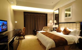 The middle room features a spacious bed, along with a sitting area and desk attached to one side at Wansheng International Hotel