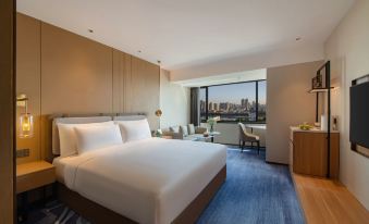 a hotel room with a king - sized bed , a television , and a window overlooking the city at Guangzhou Hotel