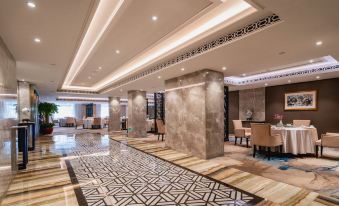 a luxurious hotel lobby with marble floors , a marble wall , and modern furniture arrangements , as well as a ceiling decorated with a geometric pattern at Lakeside Hotel