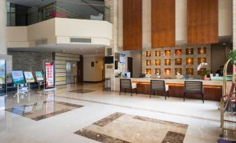 a modern and spacious lobby with marble flooring , large windows , and a reception desk , along with a waiting area and art gallery at Royal Hotel