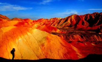 The landscape is adorned with mountains and painted hills, showcasing unique colors not found in other countries at Colorful Danxia Yimi Sunshine Inn