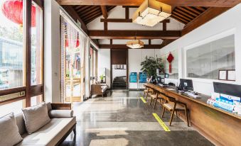 The living room or dining area features a long hallway with large windows and floor-to-ceiling glass at Mutianyu Great Wall Hotel