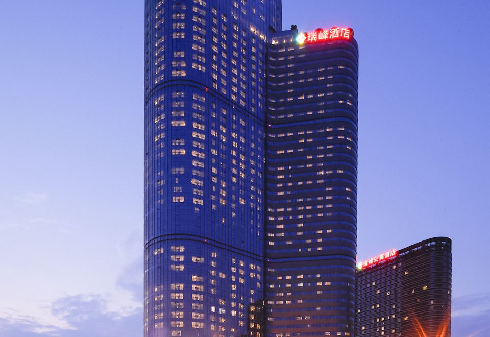 At night, there is a large building with many windows and an office tower in the middle at Rayfont Hotel & Apartment Chengdu
