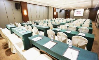 a large room arranged with long tables and chairs facing the front for an event at Ramada by Wyndham Beijing Airport