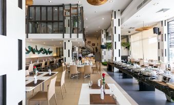 a large , modern restaurant with multiple dining tables and chairs , as well as a bar area at Grand Ratchapruek Hotel