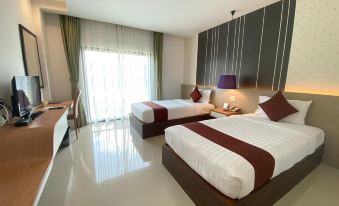 a modern hotel room with two beds , white bedding , and a desk , along with a balcony view at Siva Royal Hotel