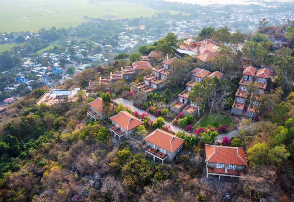 a bird 's eye view of a village with orange roofed houses surrounded by trees and greenery at Victoria Nui Sam Lodge