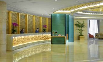 The lobby features a clean and modern design, highlighted by a large marble wall that adds an artistic touch at Radisson Blu Hotel Shanghai New World