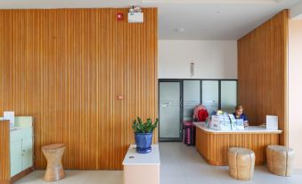 a modern , minimalist office interior with wooden walls and a reception desk , featuring potted plants and other items on display at Bandara Villas, Phuket