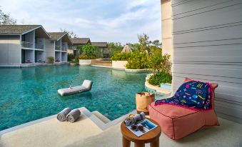 a backyard with a pool surrounded by lounge chairs and a couch , creating a relaxing atmosphere at Island Escape by Burasari