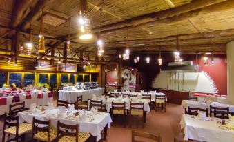 a large dining room with wooden tables and chairs arranged for a group of people to enjoy a meal together at Amboseli Serena Safari Lodge