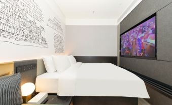 A modern bedroom with white walls and large windows features an art piece beside the bed at CITIGO hotel, Sanlitun, Beijing