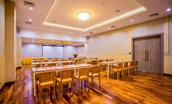 a large , empty conference room with wooden floors and tables , a projector screen at the front , and several chairs arranged in rows at Kacha Resort & Spa, Koh Chang