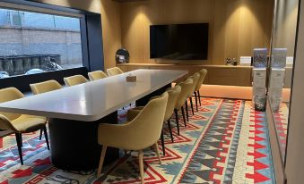 In the conference room, there is a large table and chairs, and adjacent to it is an office space along the wall at Qiuguo Hotel (Beijing Sanlitun Gongti Branch)
