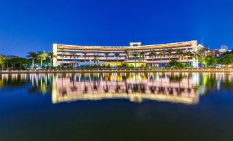 a large hotel building situated next to a body of water , illuminated at night at Swan Hotel
