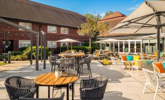 an outdoor dining area with several tables and chairs , creating a pleasant atmosphere for guests at Holiday Inn Aylesbury