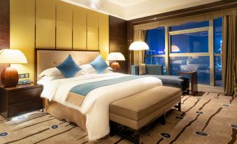 The room features a bed with large windows and decorative headboards on each side at Expo Center Hotel