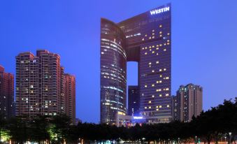 In the middle of an urban area, there is a large building with many windows that is illuminated at night at the Westin Guangzhou