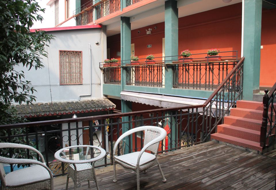 There is a balcony with chairs and a table on the first floor of an apartment or small town nearby at Beehome  Hostel