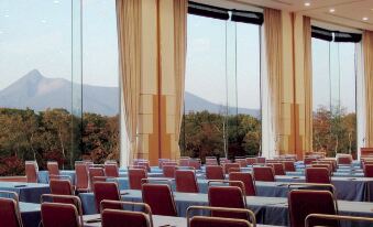a large conference room with multiple rows of chairs arranged in a semicircle , providing seating for attendees at Hakodate-Onuma Prince Hotel